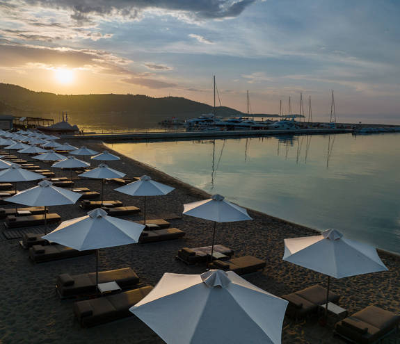 Miraggio beach, sunbeds and umbrellas at sunrise