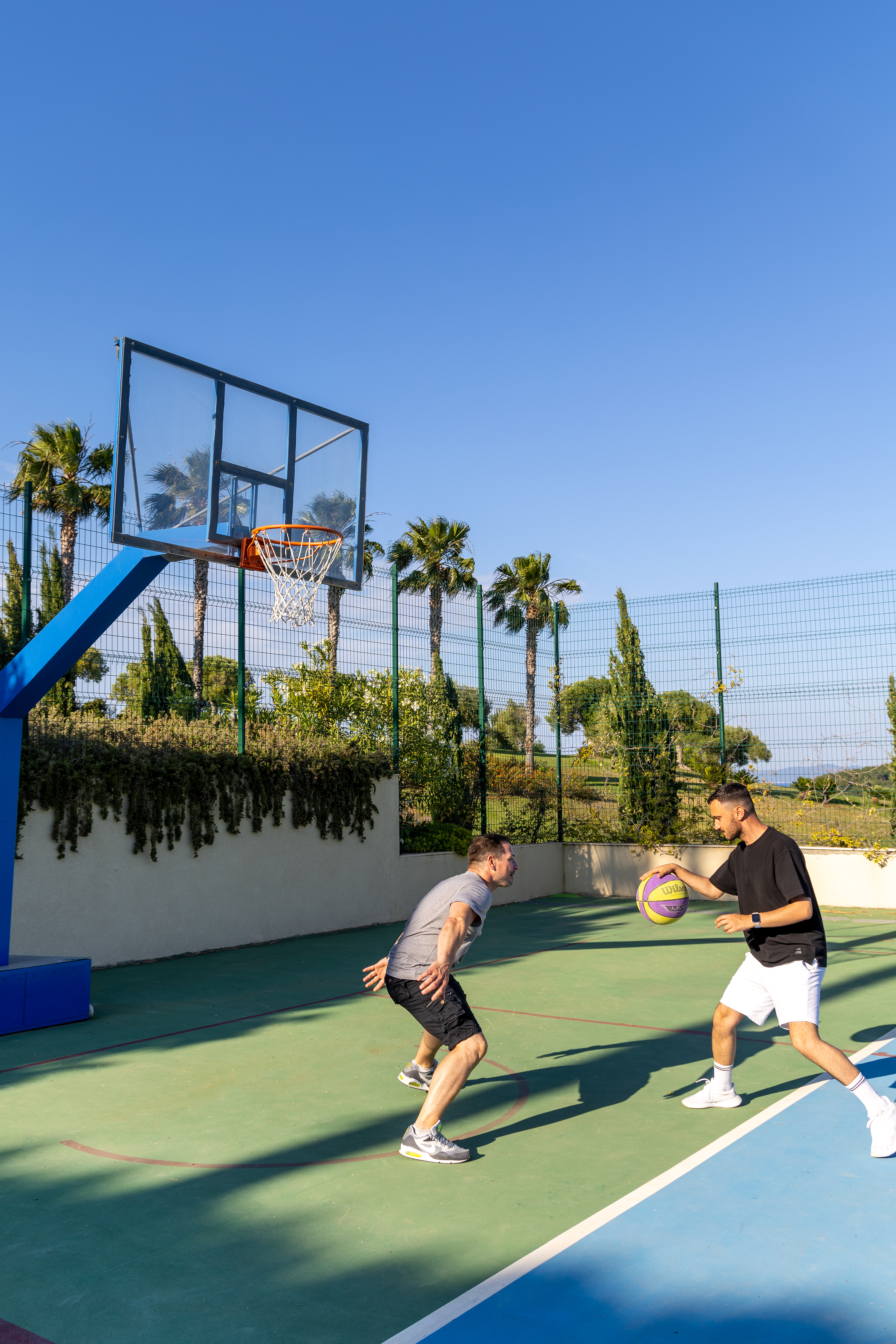 Basketball player blocking opponent's shot during an outdoor game