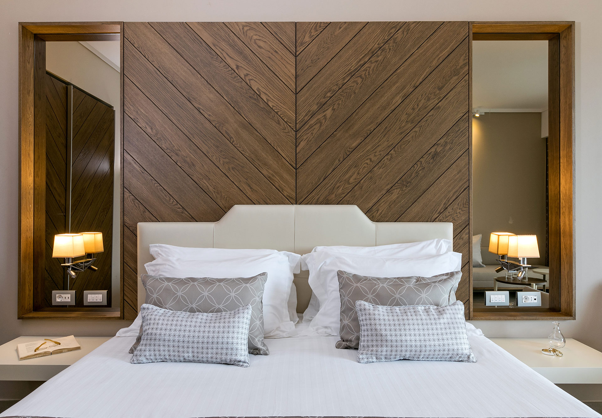 Close up of elegant double bed with patterned pillows and wood headboard