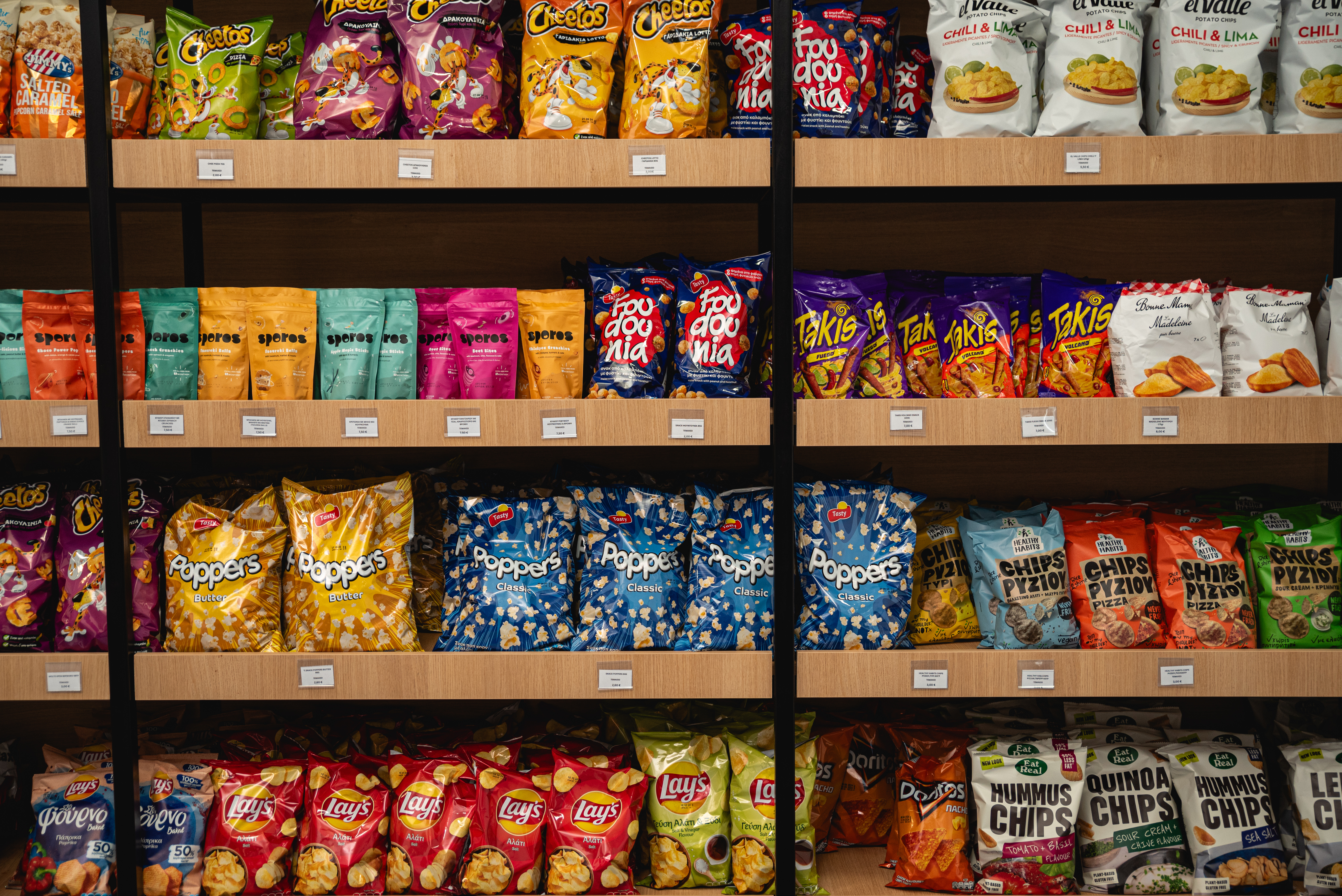 Close up of colorful snack and chip bags neatly displayed on wooden shelves