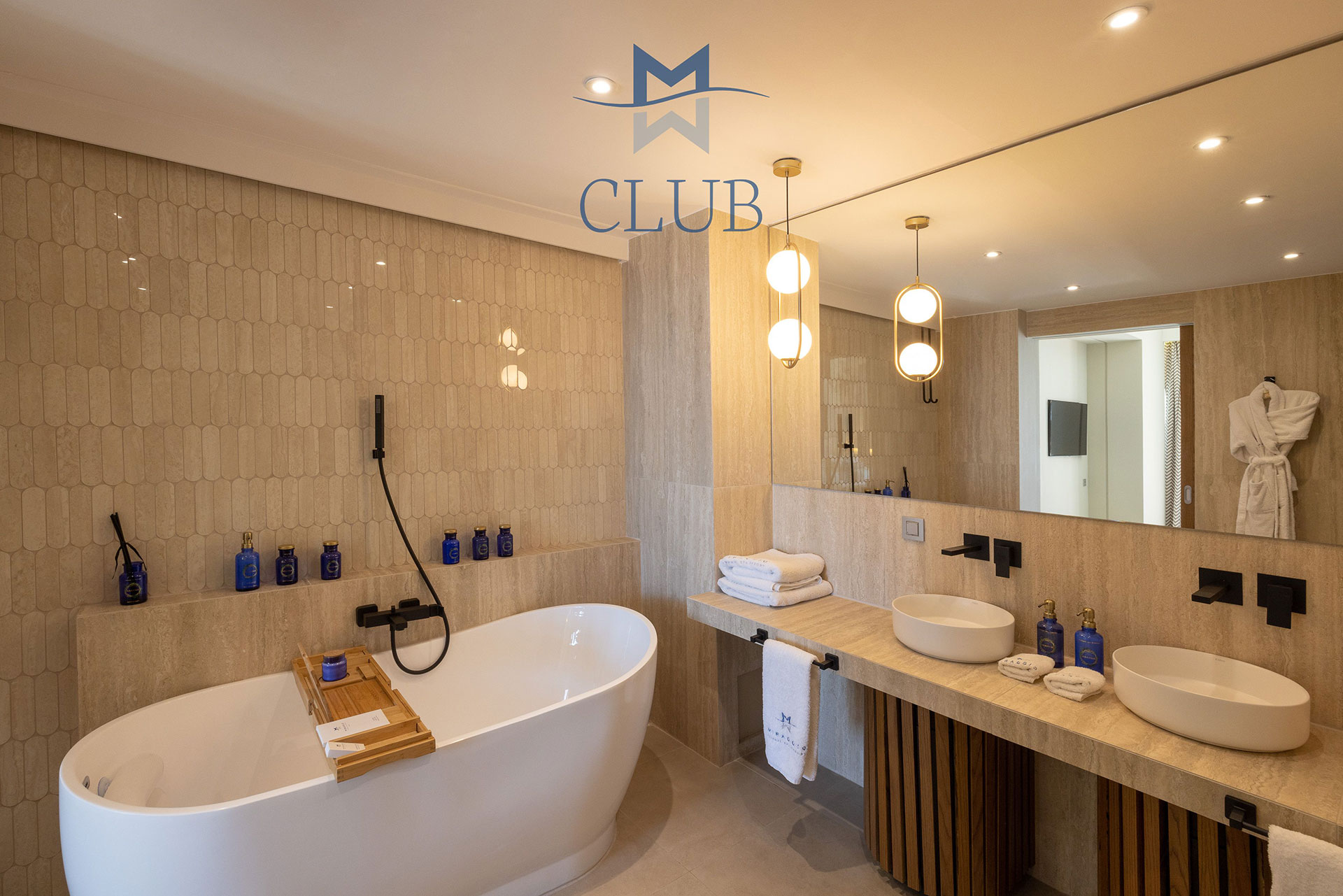 Elegant bathroom with warm lighting, dual sinks, vanity mirror and freestanding bathtub