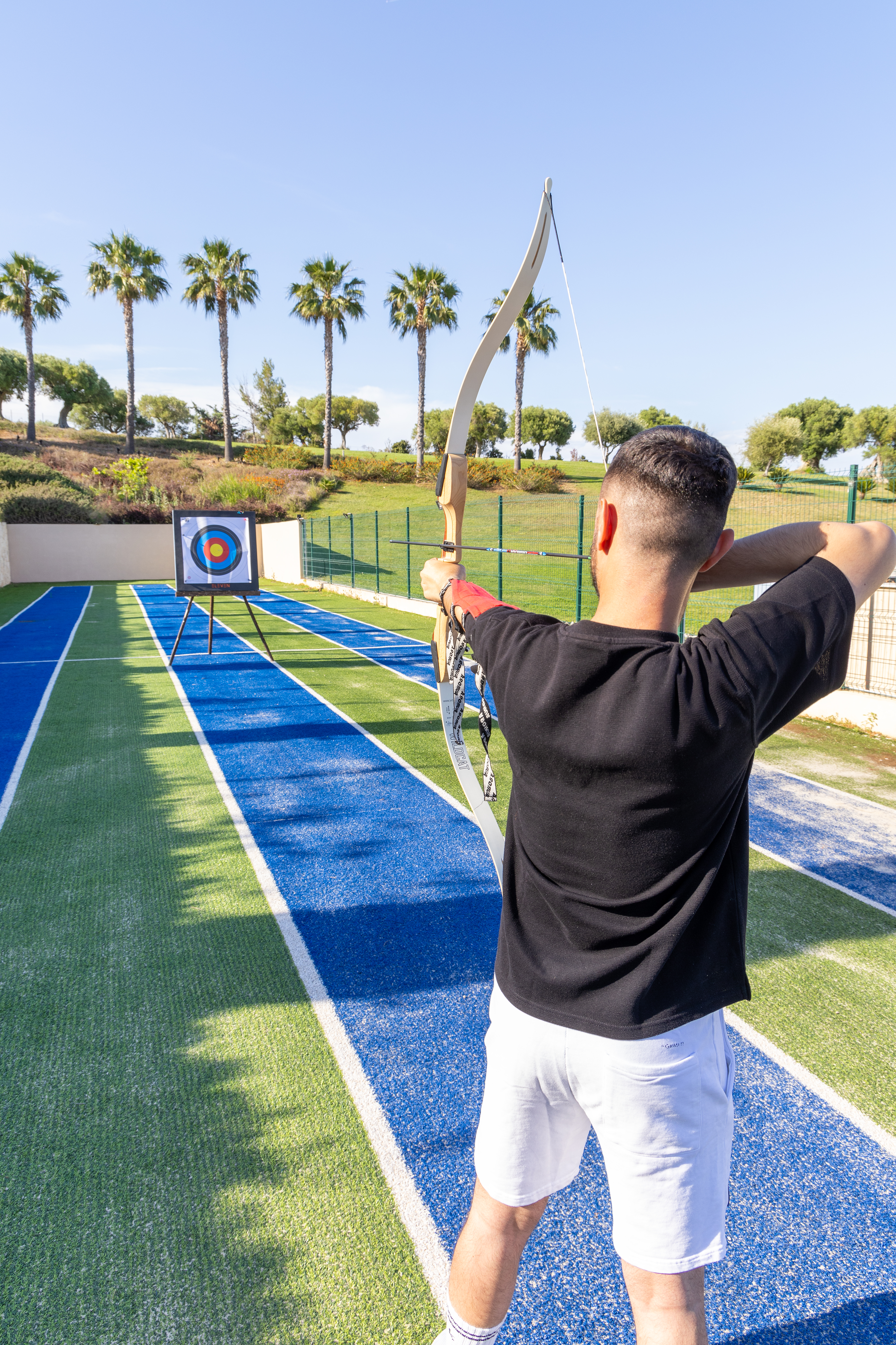 Archer aiming carefully with bow and arrow at the outdoor archery range