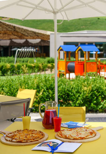 Kids Restaurant kids table with food and drinks and the playground in the background