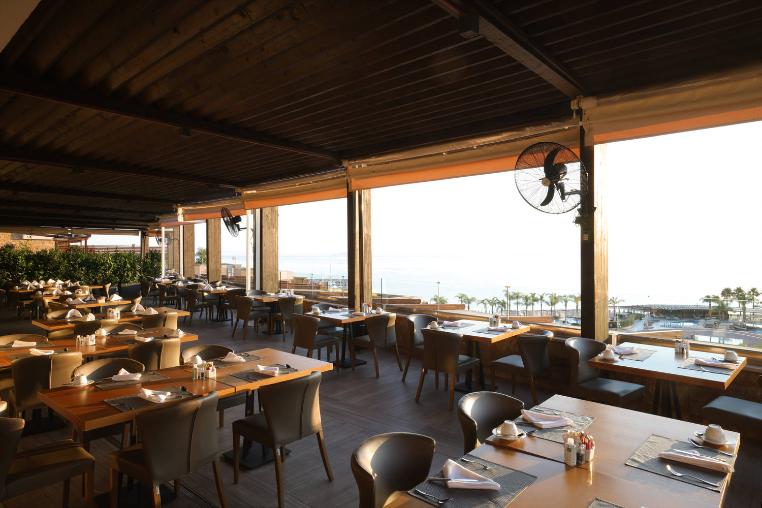 Kritamo restaurant bright exterior with wooden roof, and tables and sea view