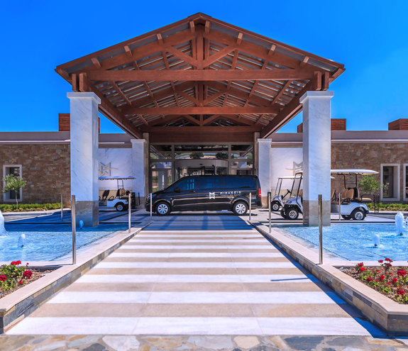 Miraggio Resort entrance with marble pillars, water fountains, and luxury transfer vehicles