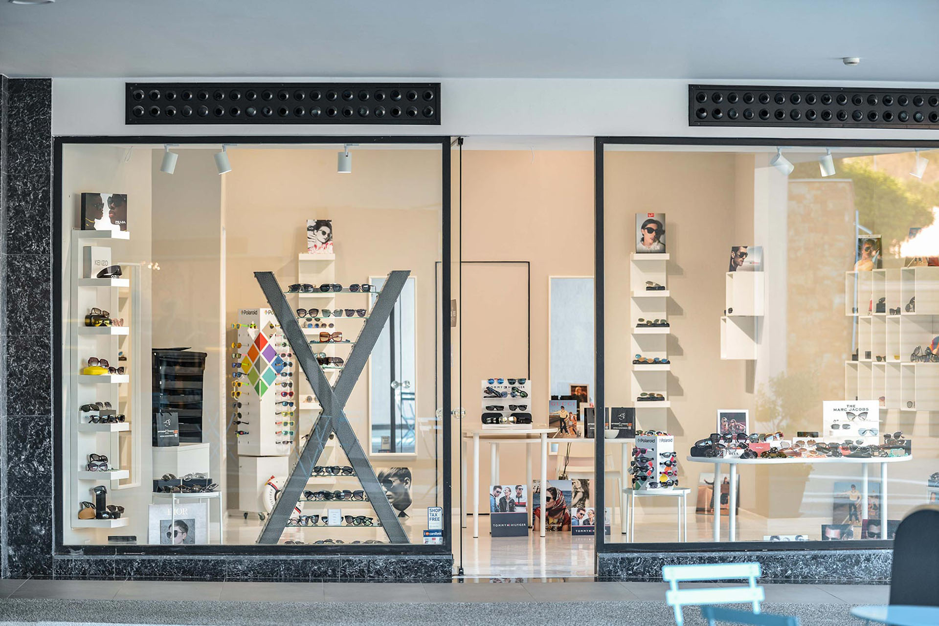 Full view of Optikon Xpress storefront with illuminated eyewear displays