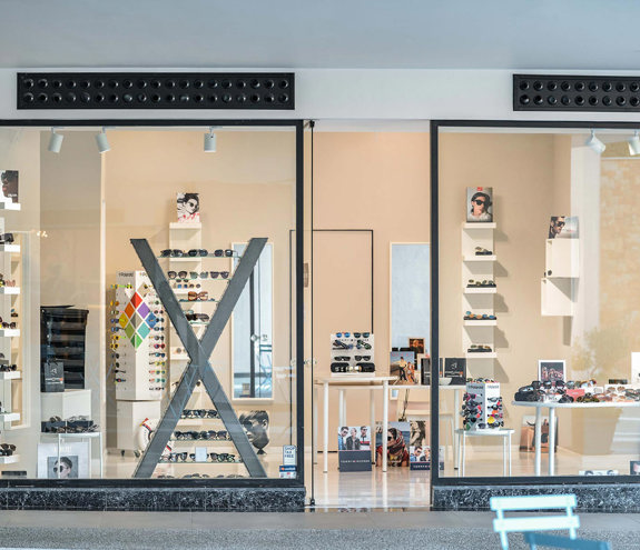 Full view of Optikon Xpress storefront with illuminated eyewear displays