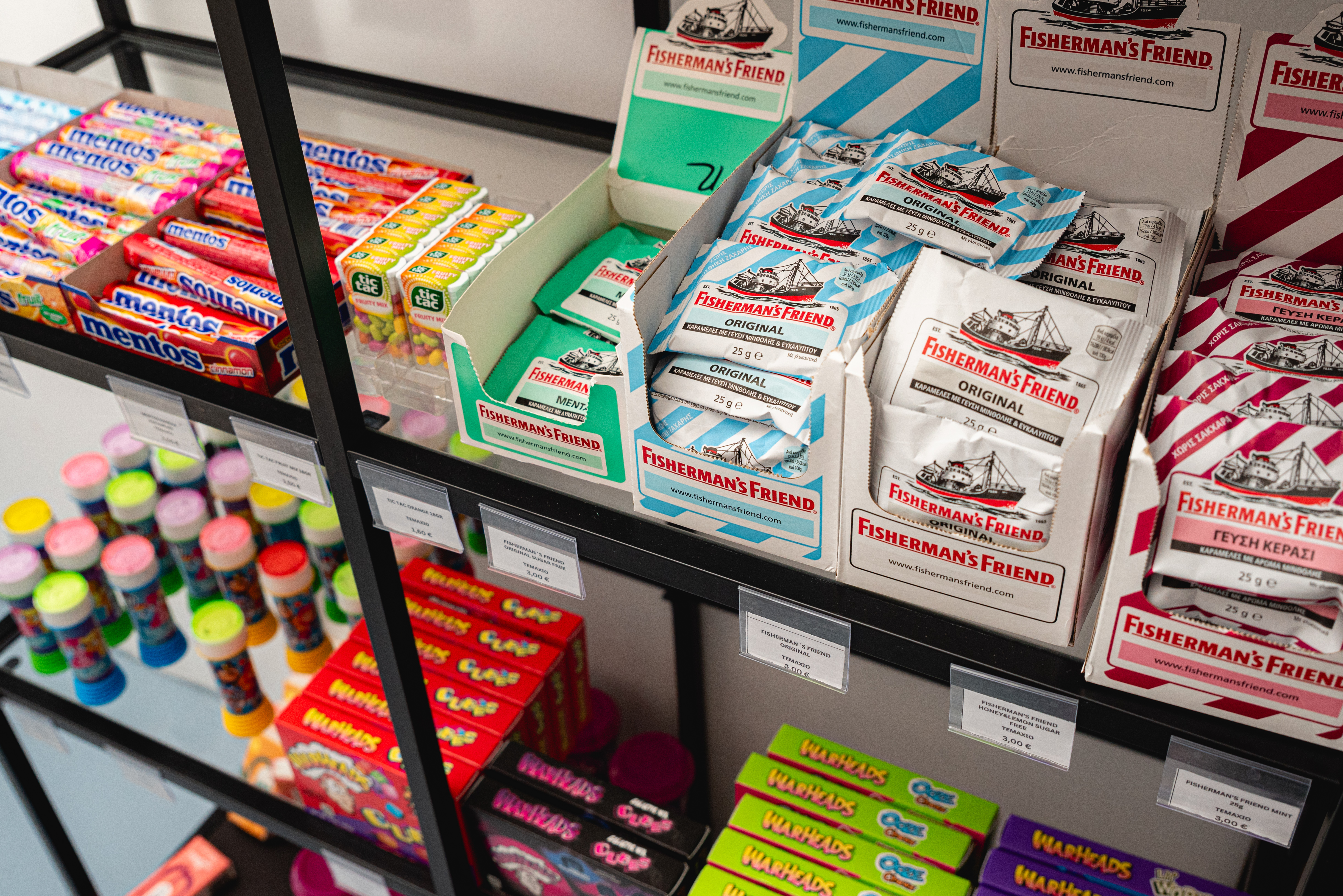 Shelves stocked with Mentos, Fisherman's Friend, and other colorful candies