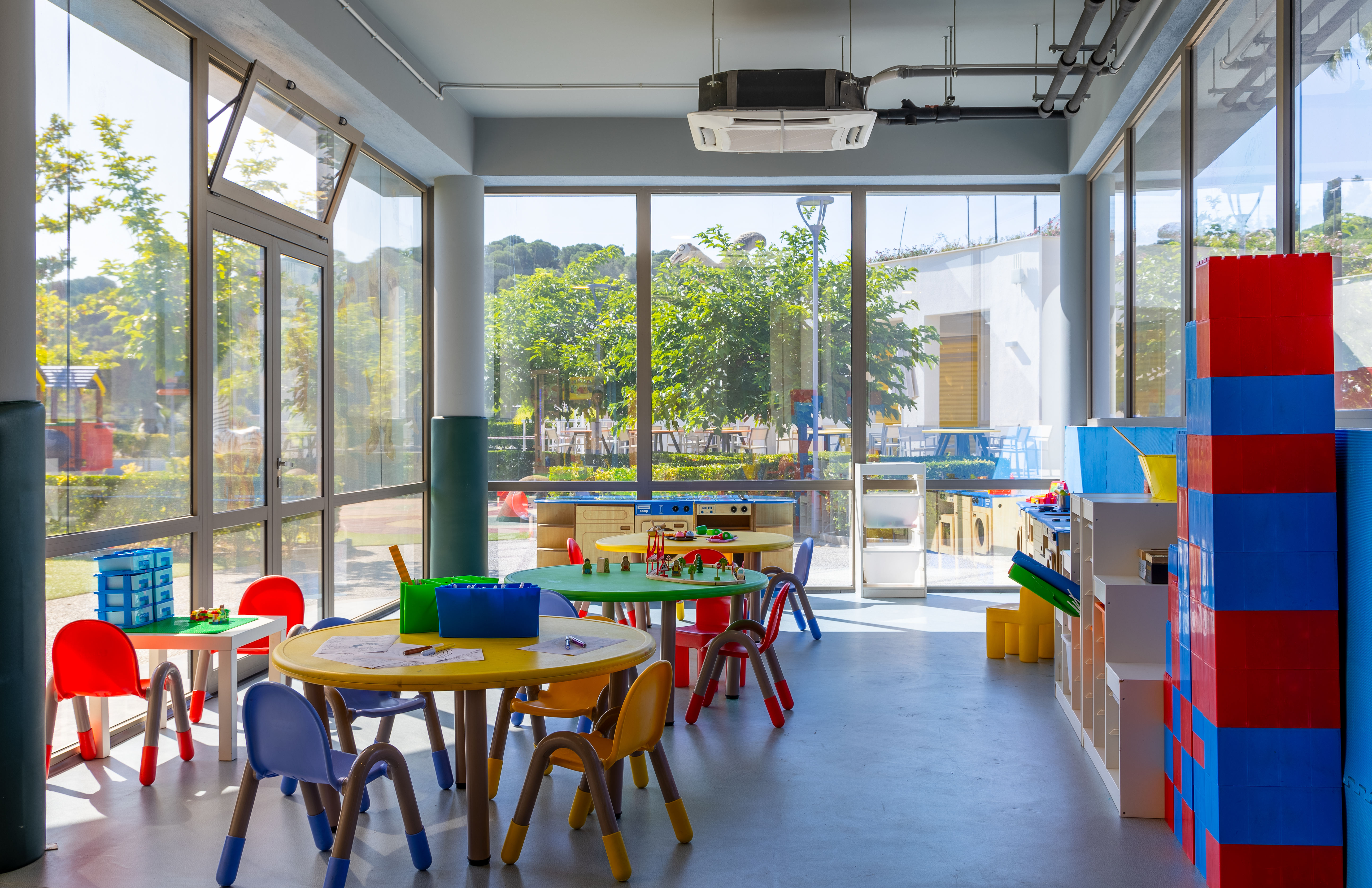 Bright indoor playroom with colorful chairs, activity tables, and creative toys at Kids Planet