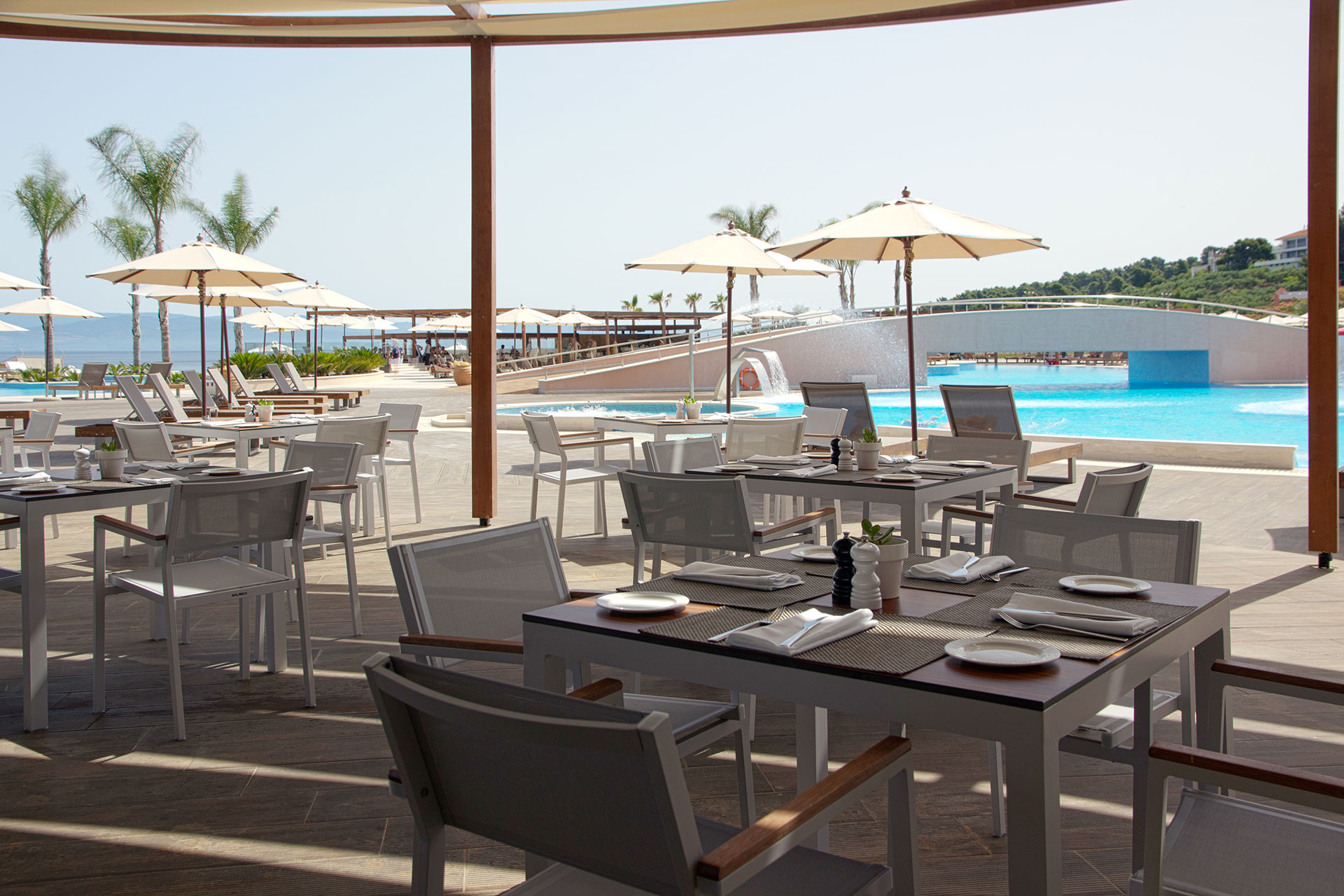 Oasis Pool Bar outdoor seating under the shadow of umbrellas near the pools