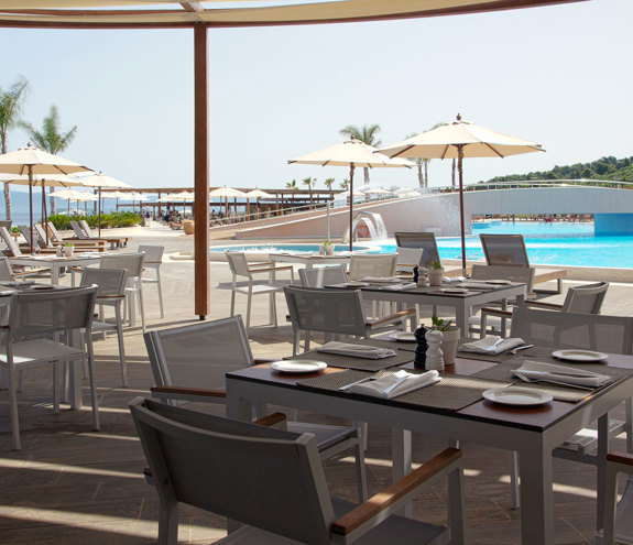 Oasis Pool Bar outdoor seating under the shadow of umbrellas near the pools
