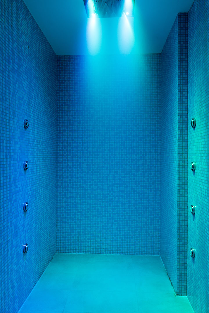 Chromotherapy shower room with blue lighting and mosaic tiles