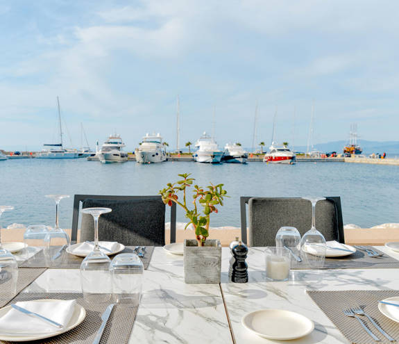 Toroneo Restaurant table with plates and glasses with view of the marina
