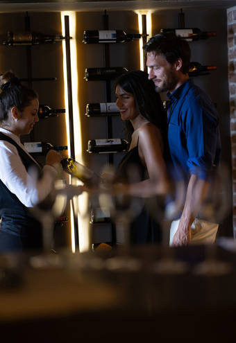 Couple being shown a wine by the waitress