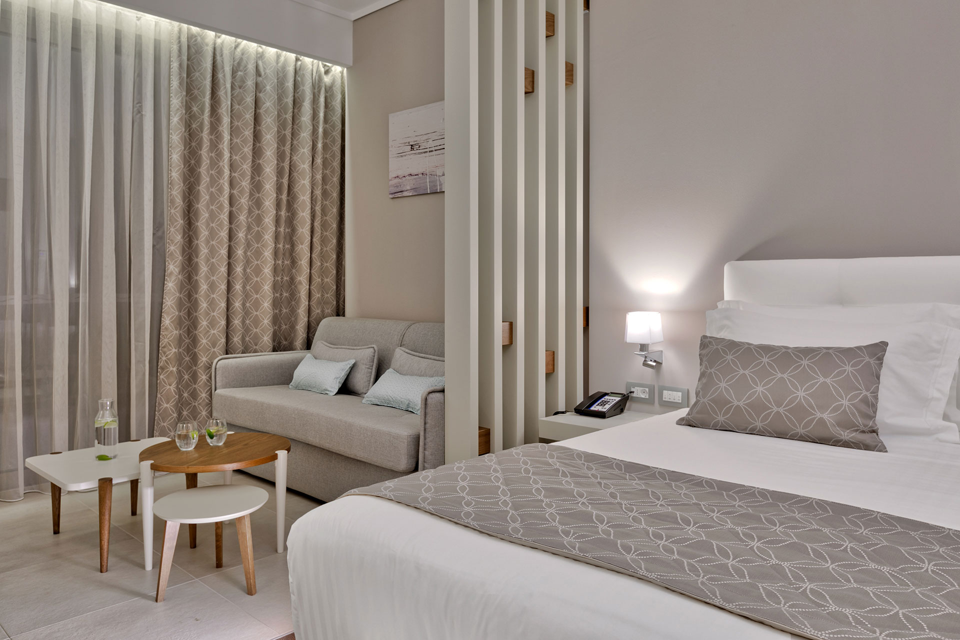 Family room with modern neutral decor, king bed, sofa, and soft ambient lighting