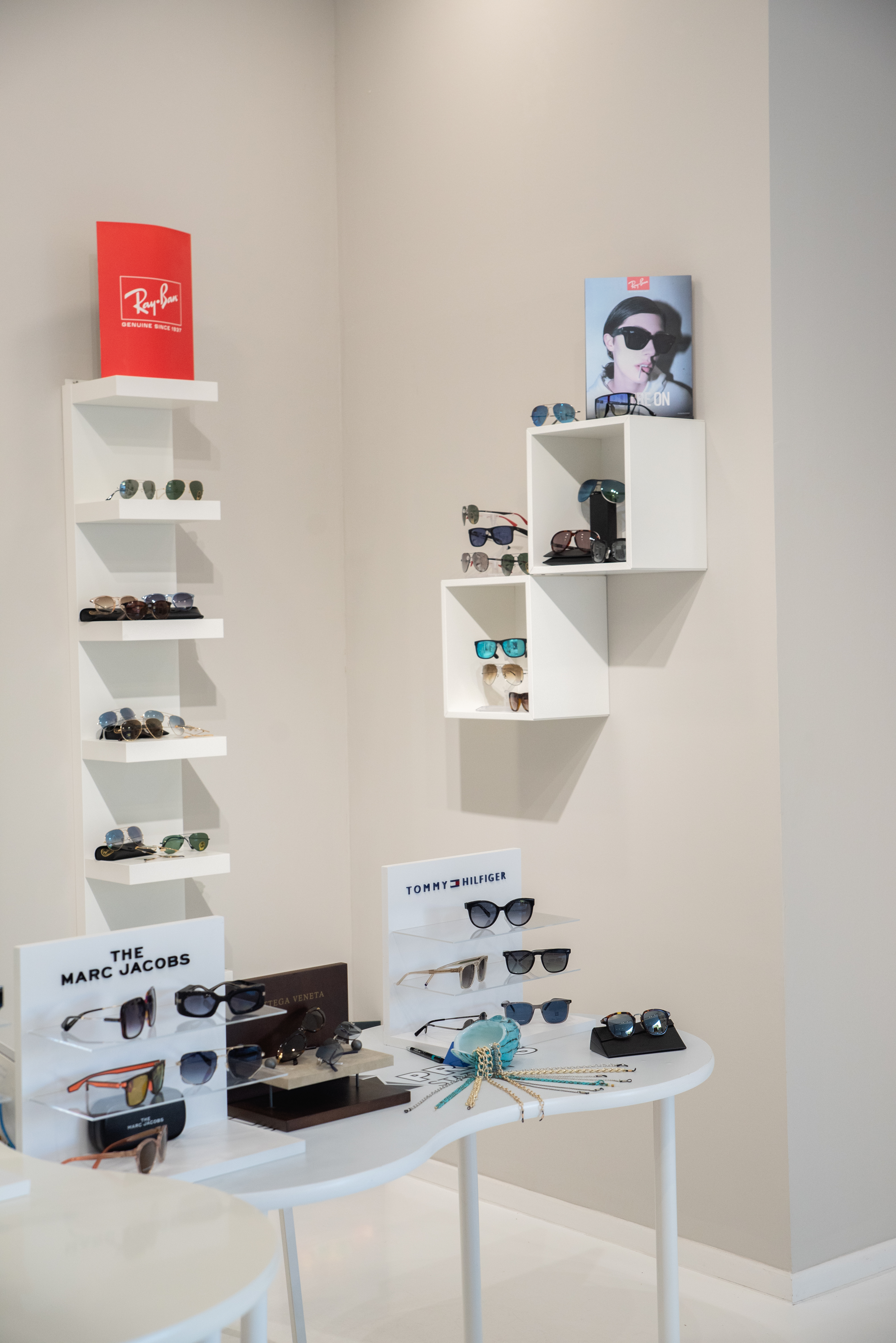 Wide variety of designer sunglasses neatly arranged on shelves