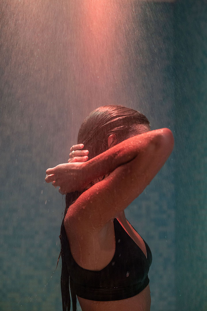 Woman enjoying sensory shower with colored lighting at Myrthia Thermal Spa