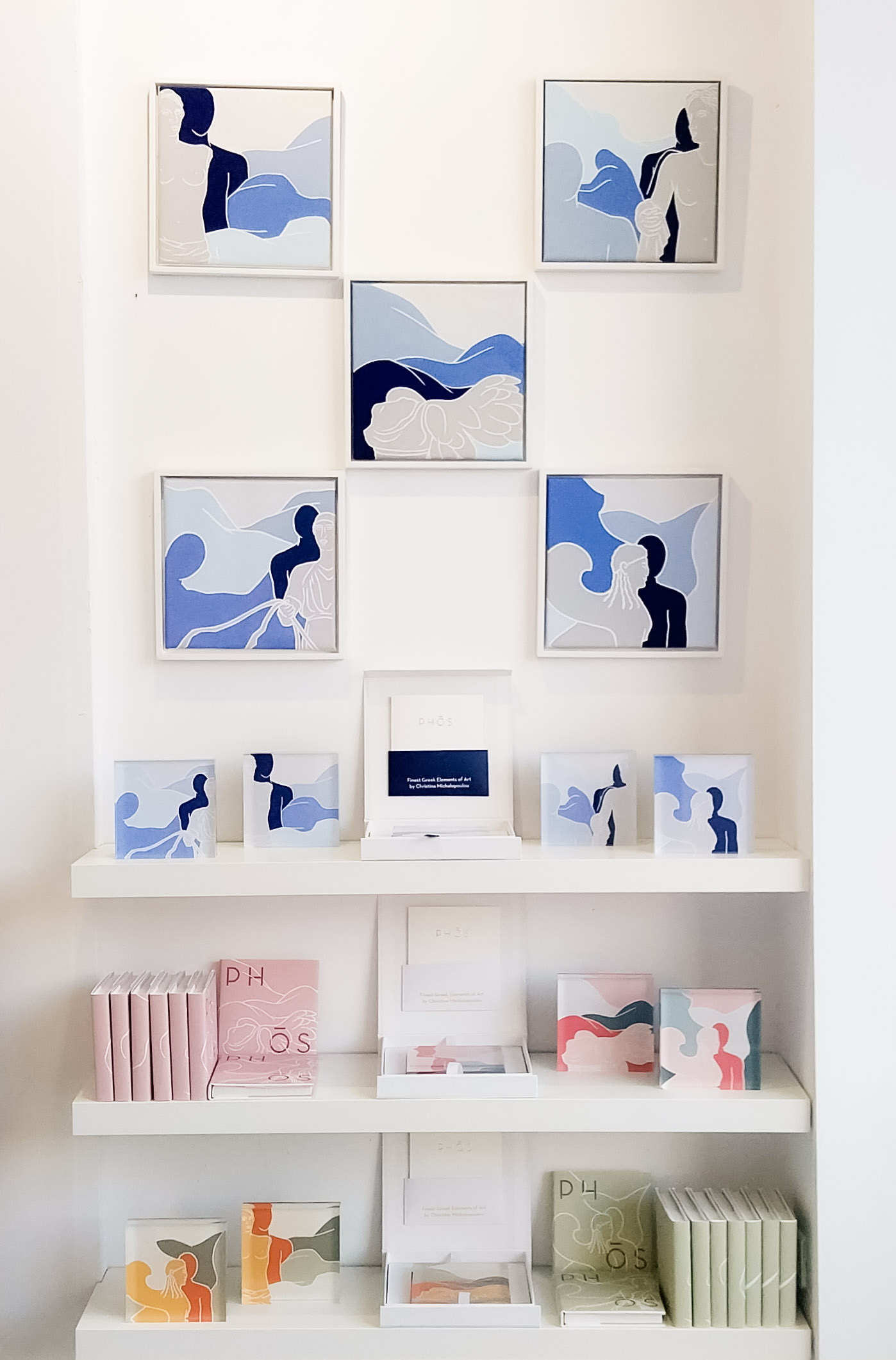 Abstract blue-themed painting displayed above pastel photo albums