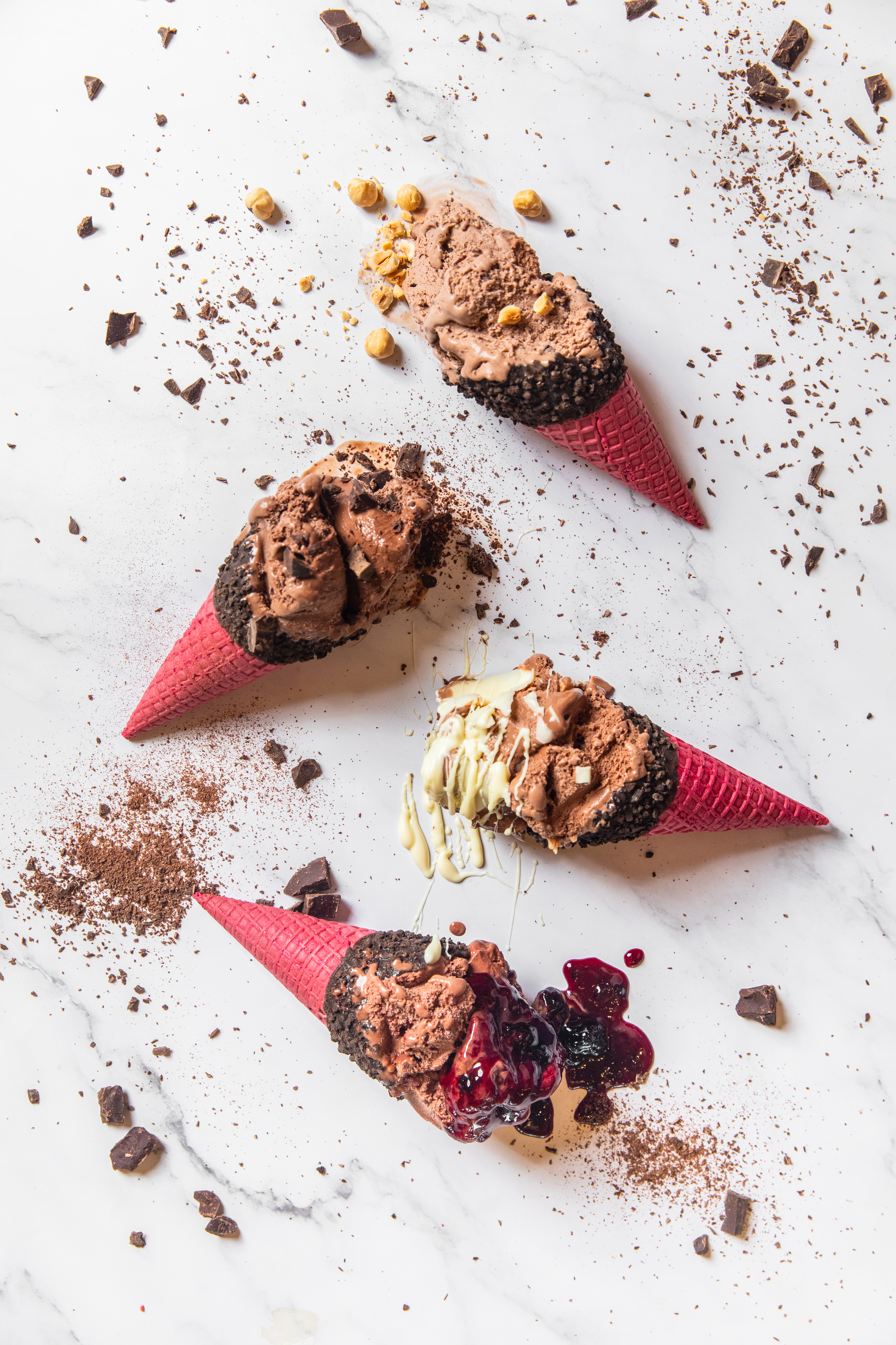 Fregio chocolate ice cream cones with red wafers, hazelnuts, and berry topping
