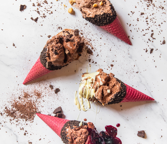 Fregio chocolate ice cream cones with red wafers, hazelnuts, and berry topping
