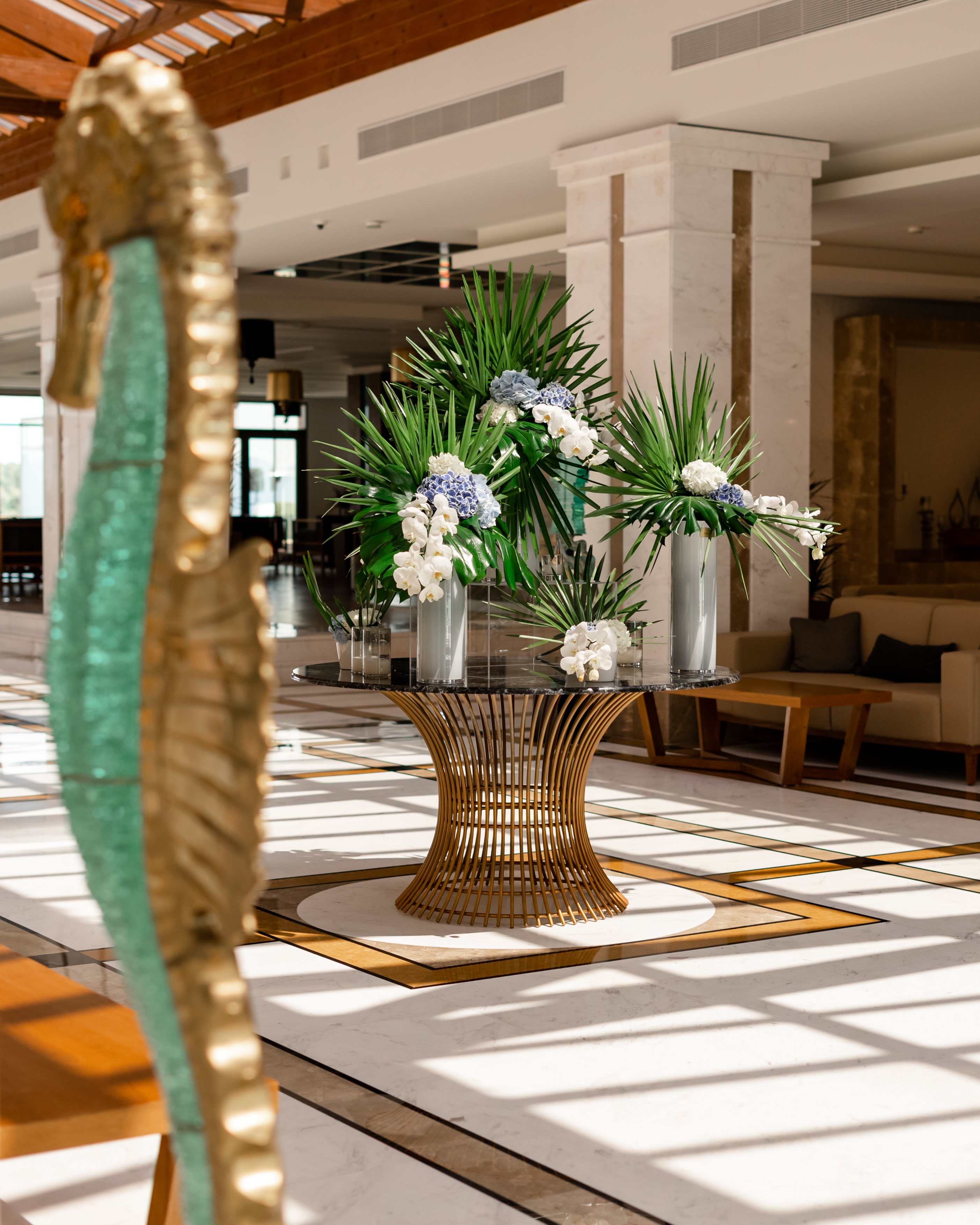 Lobby entrance table decorated with elegant flowers and plants in modern vases