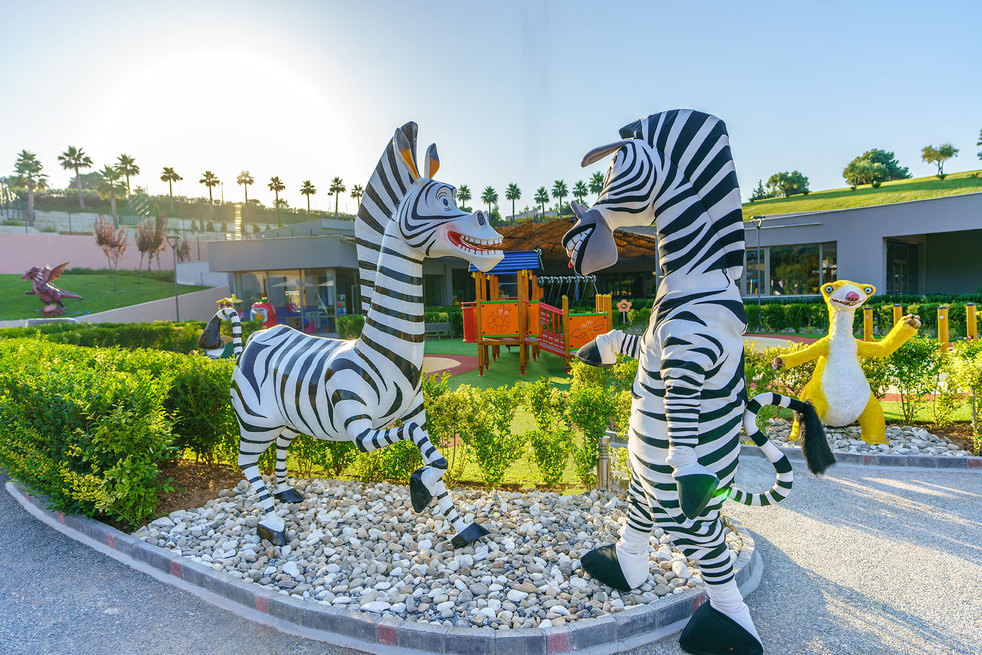 Performer in zebra costume next to the Madagascar zebra statue at Kids Planet
