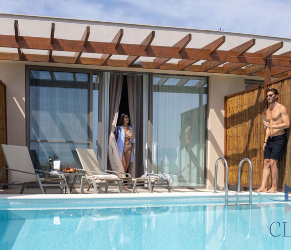 Private terrace of club sea view room with wooden pergola, sun loungers, and private pool