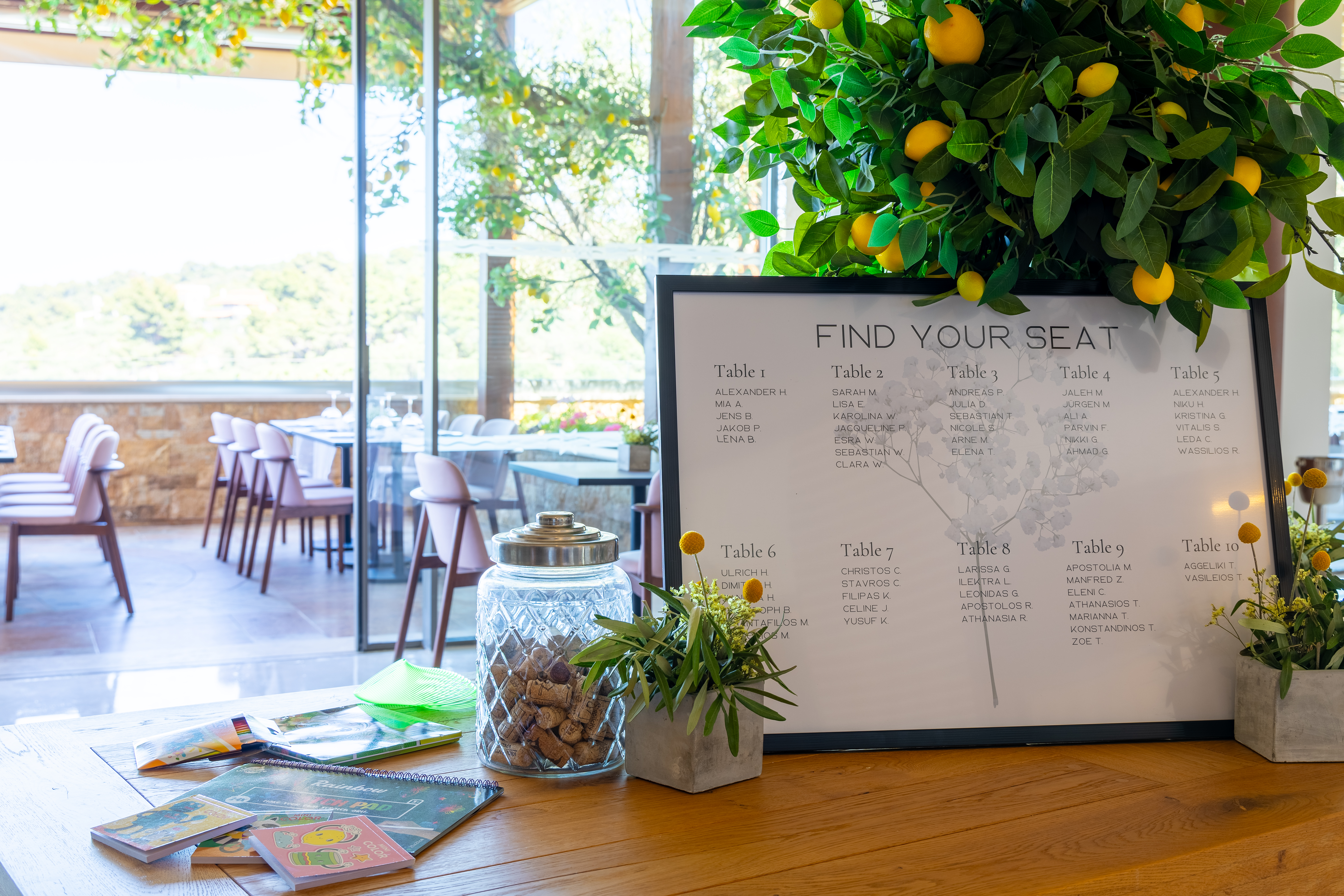 Wedding seating chart with lemon tree decor and elegant table setup in background