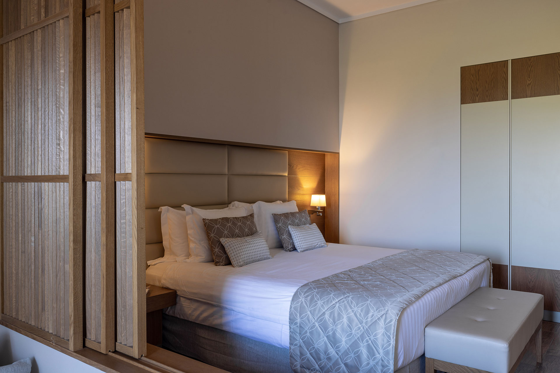 Stylish family room featuring soft lighting, padded headboard, and wooden divider
