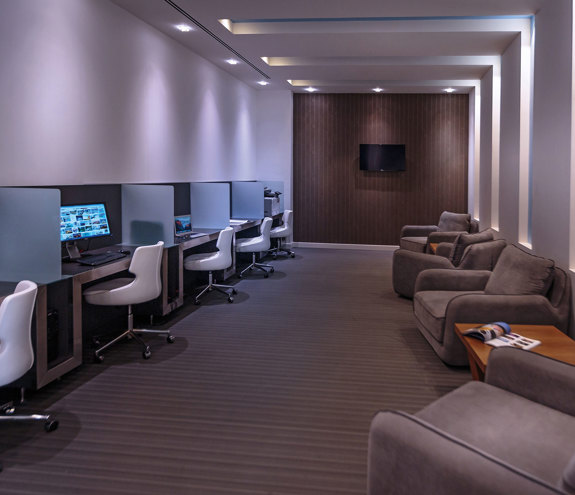 Modern business center with computer workstations and lounge seating