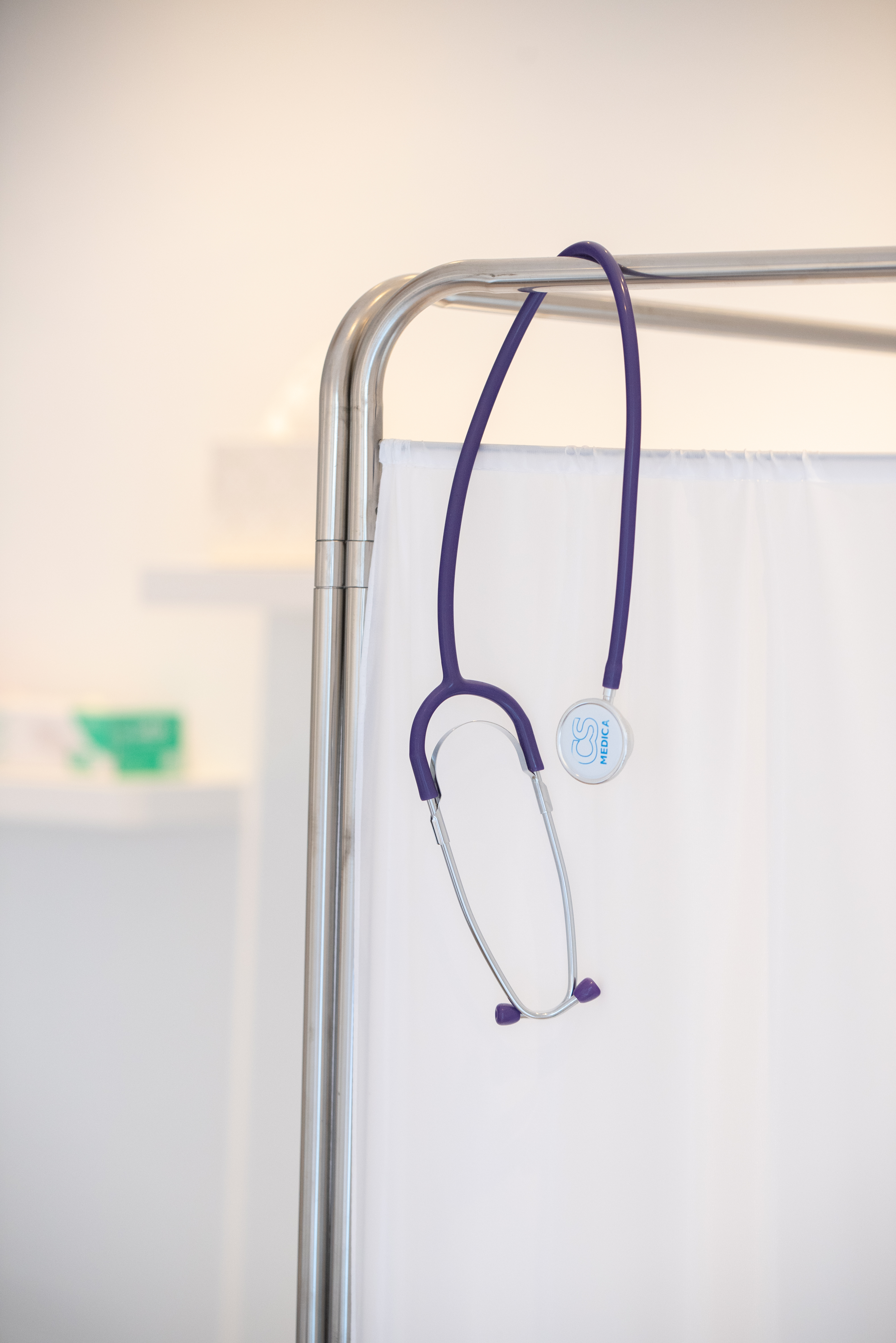 Purple stethoscope hanging on a medical privacy screen inside the clinic
