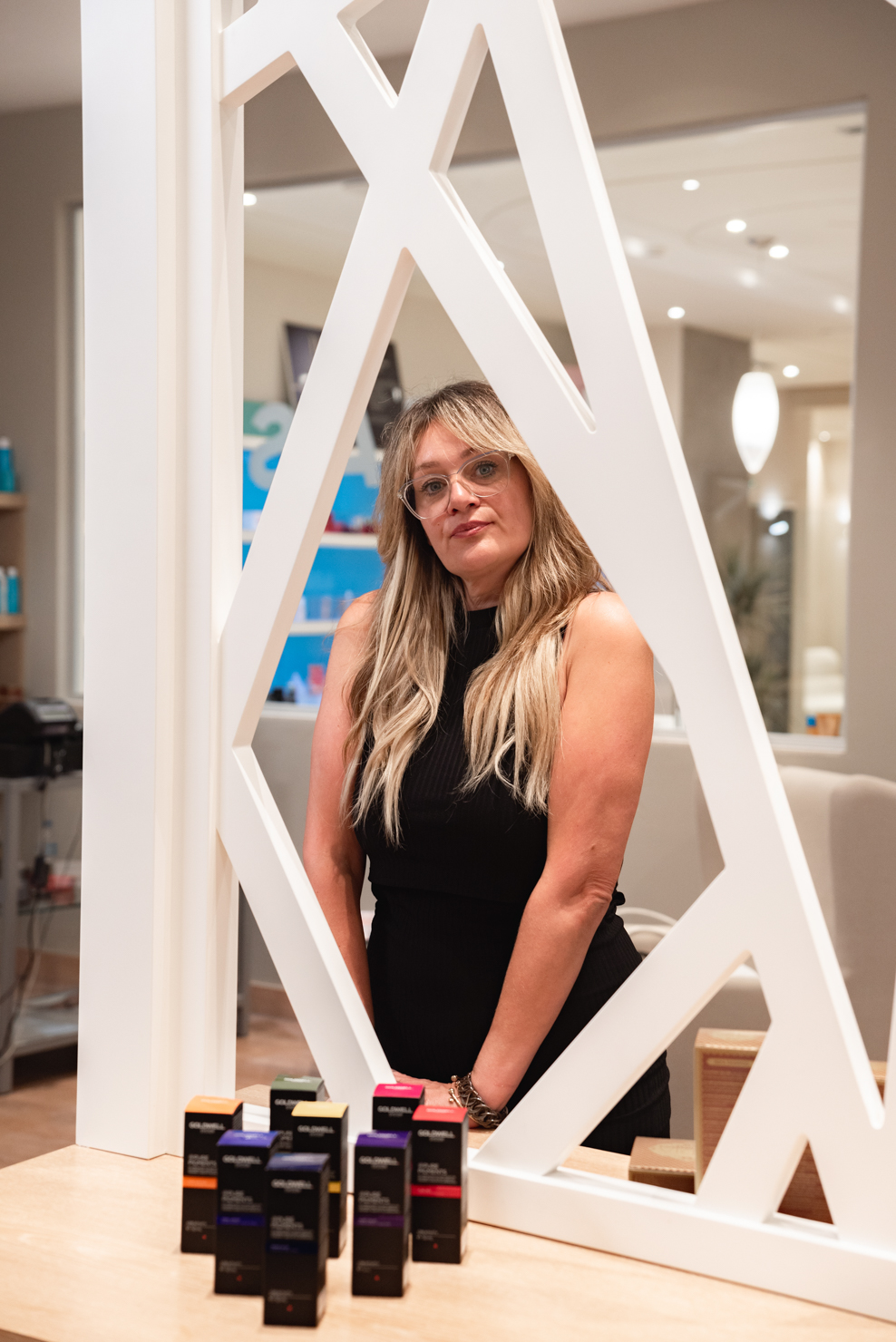 Hairstylist posing at Lefas Salon with Goldwell Pure Pigments display
