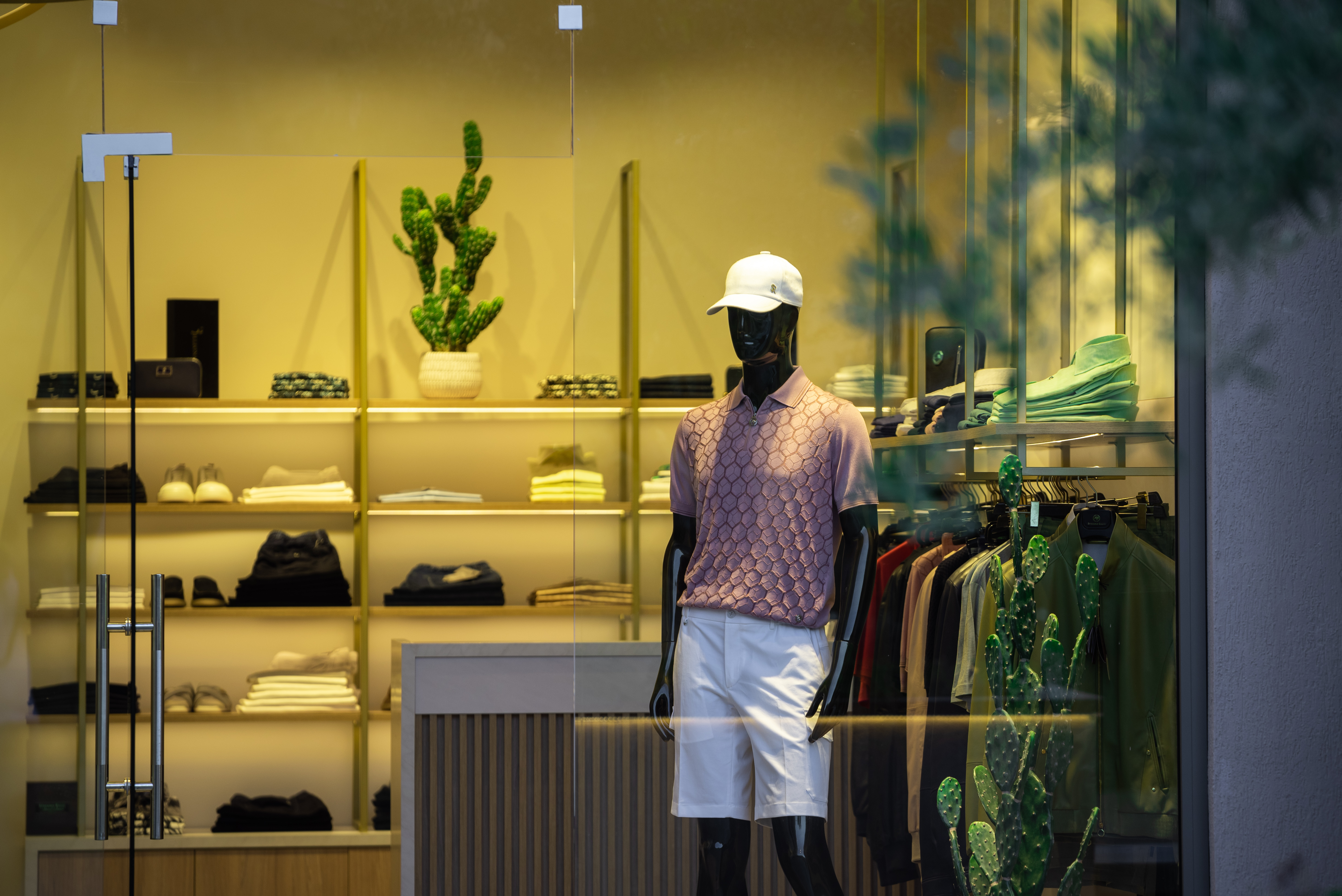 Elegant men's outfit with polo shirt and white shorts inside Diamantis boutique