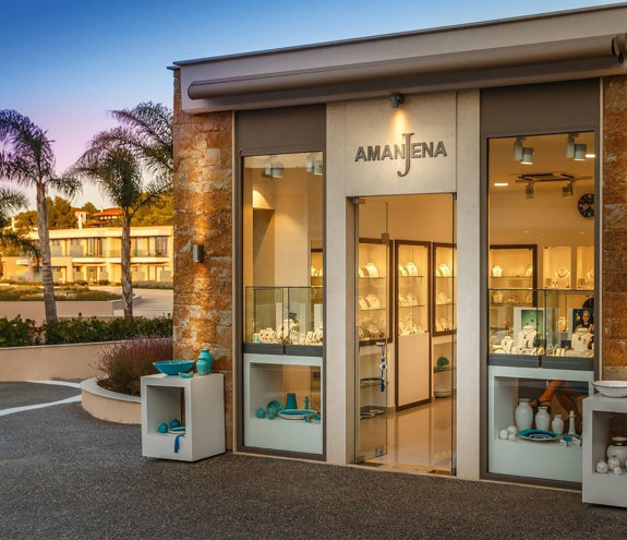 Amajena jewelry store exterior with gold-lit showcases displaying elegant pieces