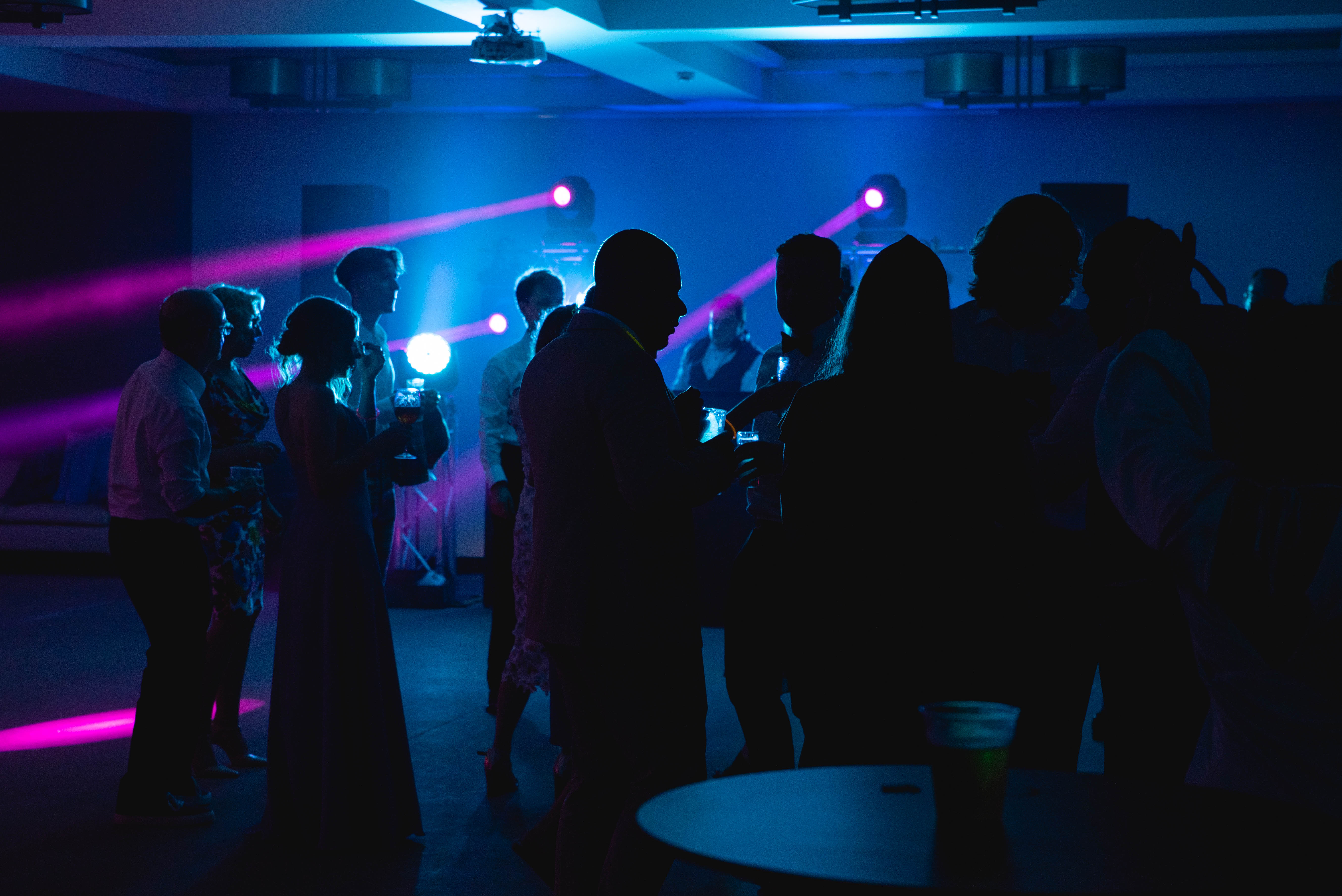 Indoor wedding dance area with guests and soft blue lighting