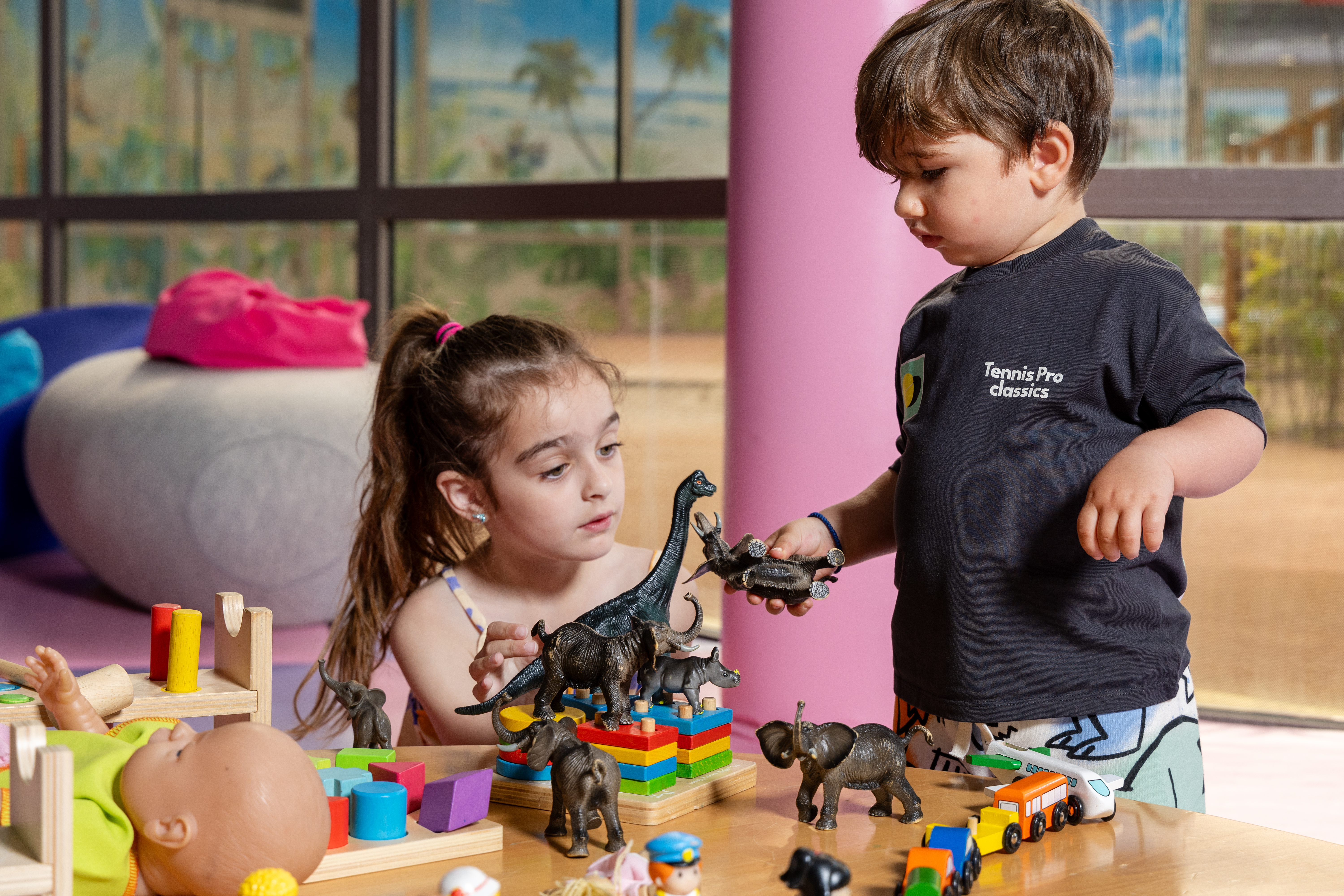 Two children playing with toy animals and colorful blocks at the Kids Planet playroom