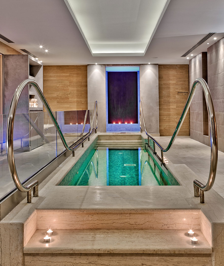 Interior cold-plunge pool with stepping stones and cool ambient lighting