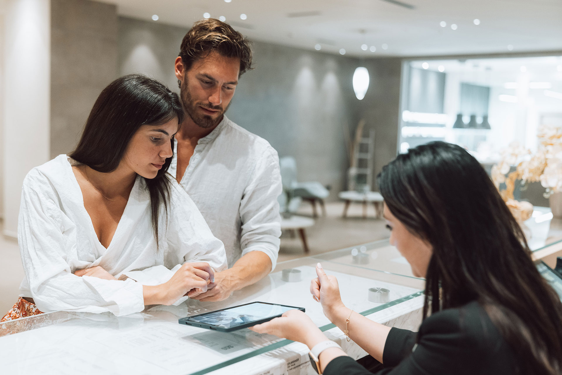 Couple checking in at the spa reception with digital tablet assistance