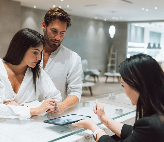 Couple checking in at the spa reception with digital tablet assistance