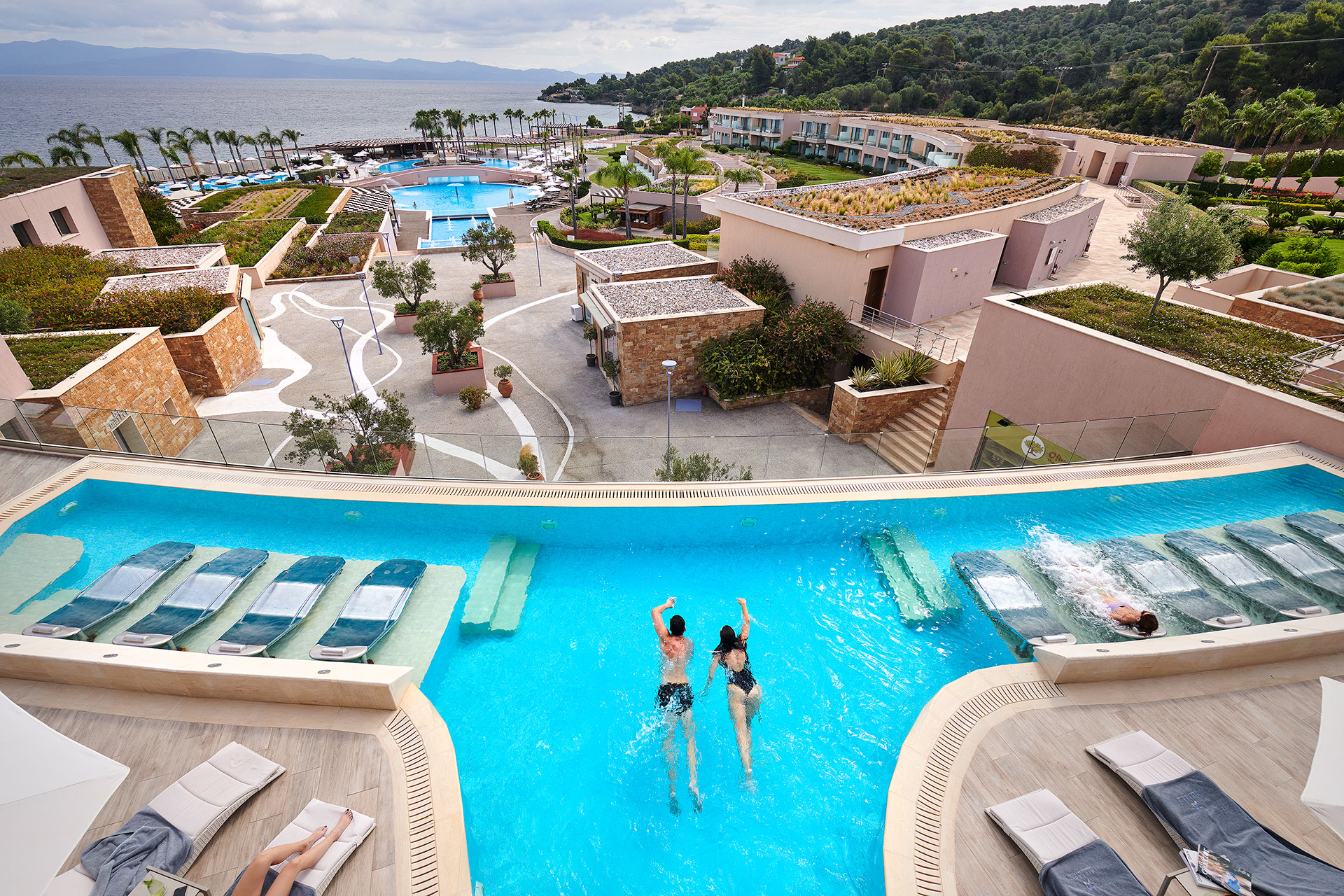 Couple swimming in hydrotherapy pool overlooking the Aegean Sea