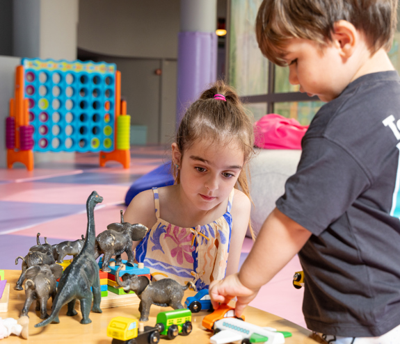 Children playing with toy animals and cars at the colorful Kids Planet indoor play area