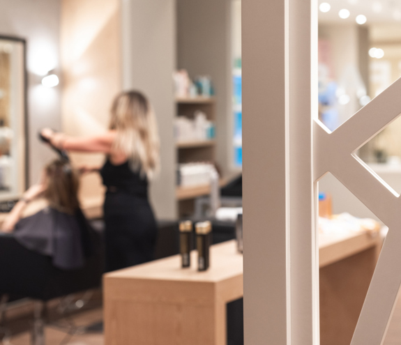 Modern hair salon interior with stylist working on guest's hair