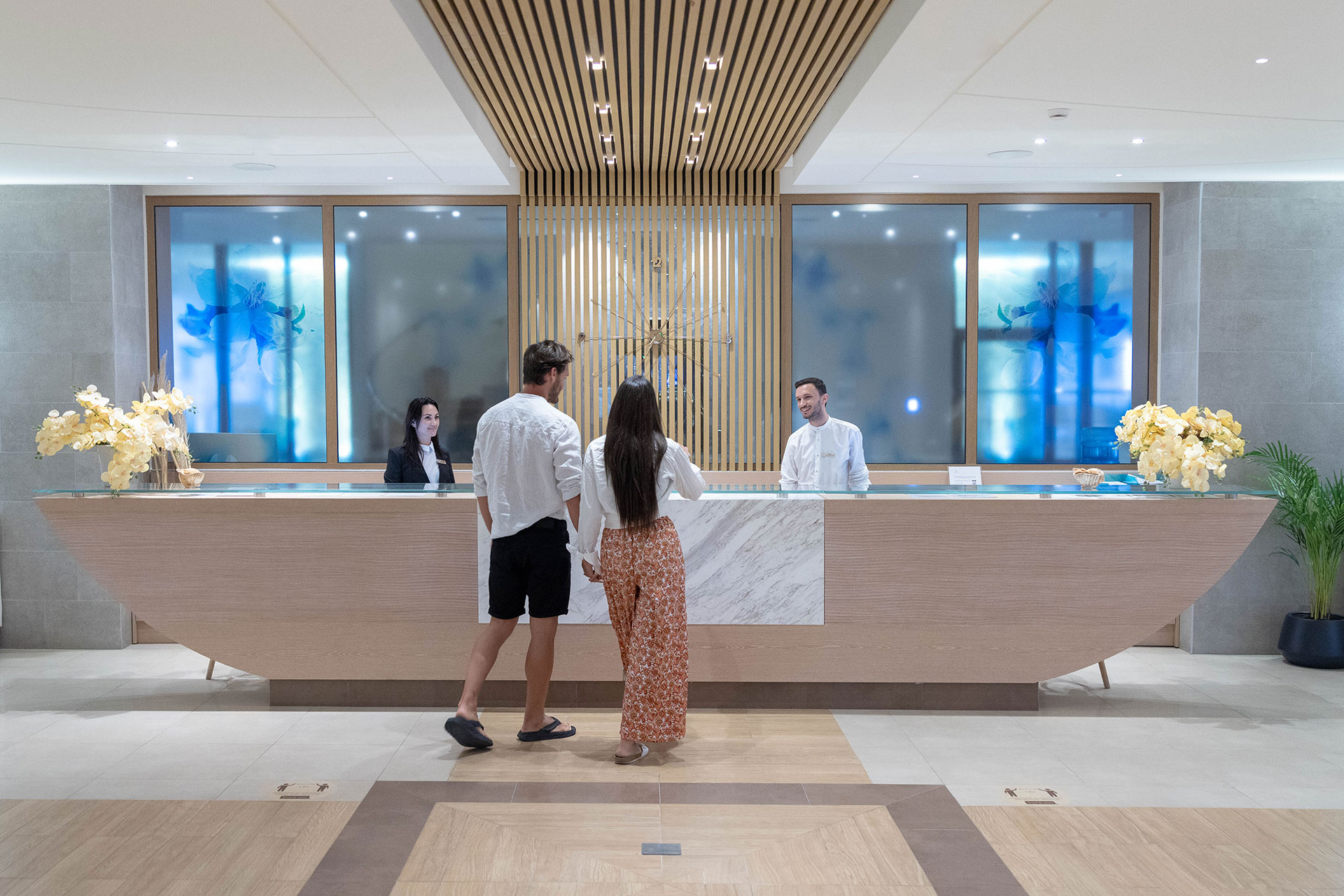Guests welcomed at the elegant spa reception with marble counter and warm lighting