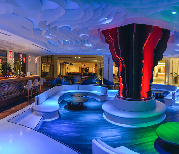 Vibrant Lobby bar interior with colorful ambient lighting in blue, red, and green accents