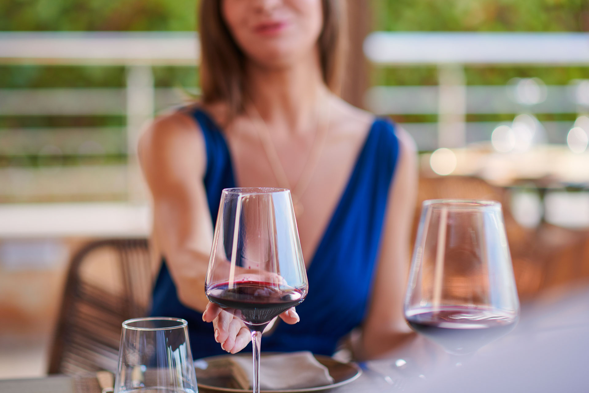 Guest enjoying a glass of red wine at Sommelier's 8 restaurant terrace