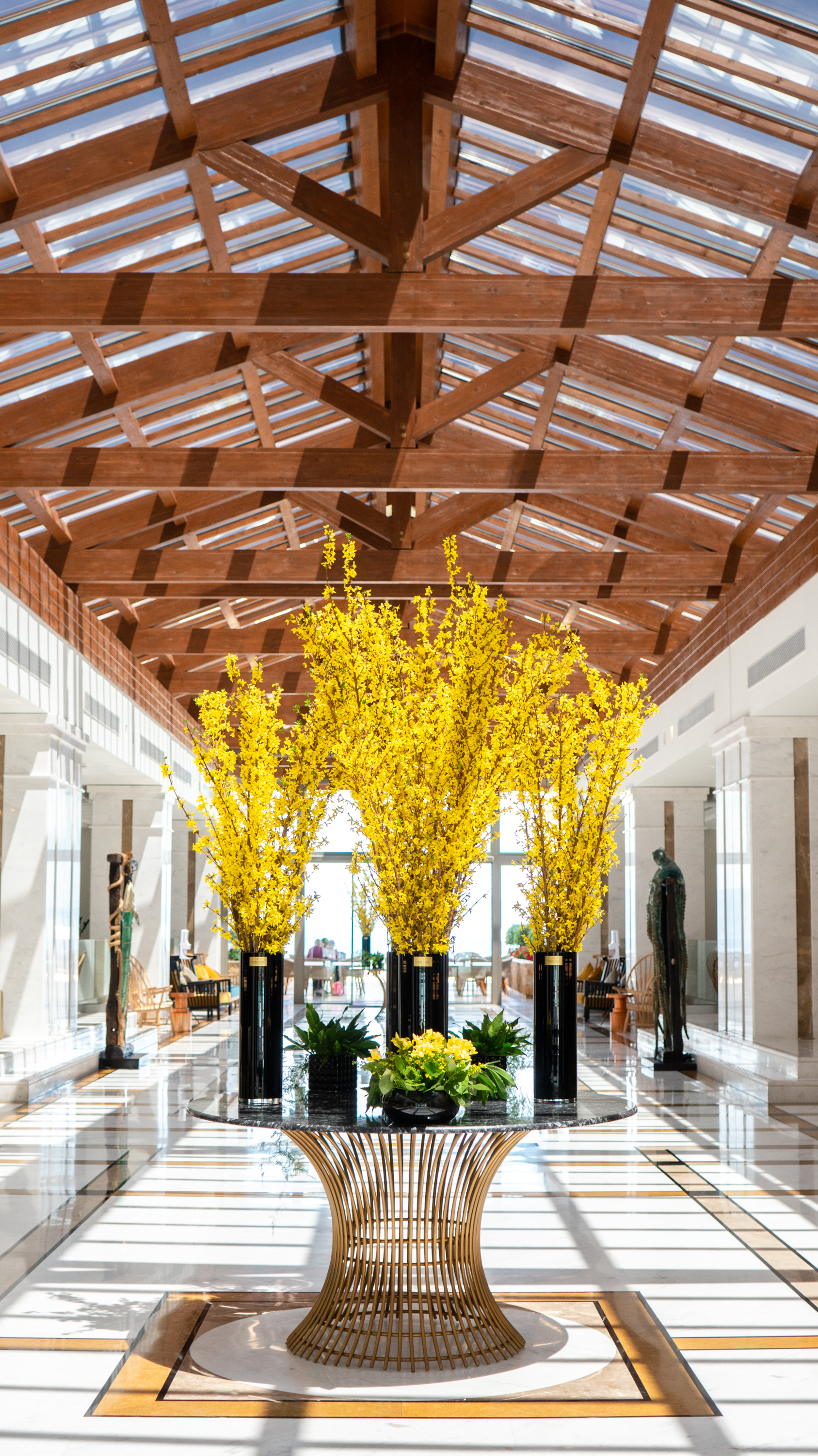 Lobby table with long black planter holding vibrant yellow foliage