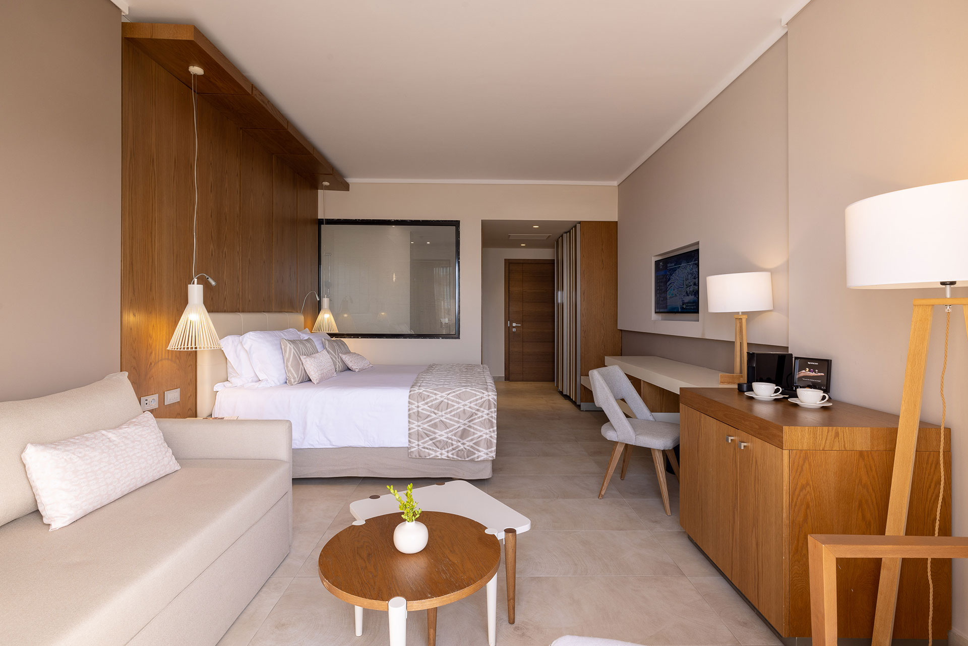 Spacious deluxe room with king size bed, seating area, working desk and modern design