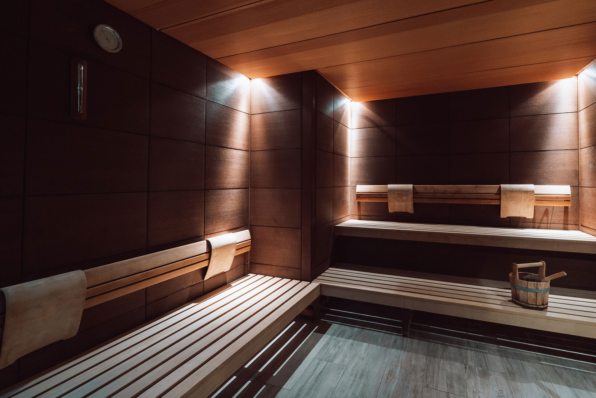 Modern wooden sauna interior with warm lighting and seating benches