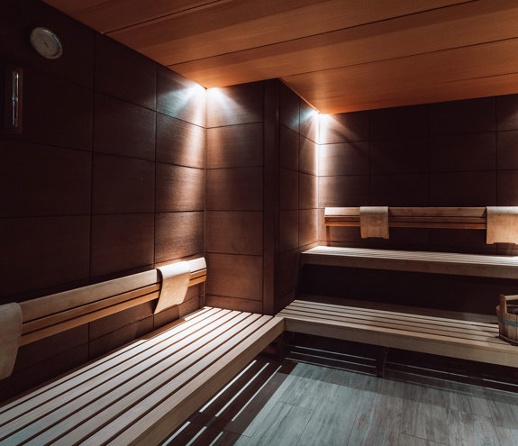 Modern wooden sauna interior with warm lighting and seating benches