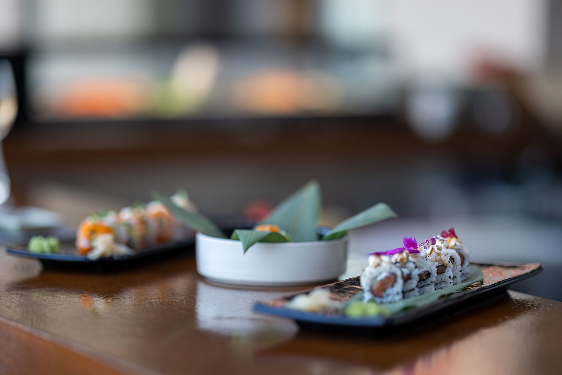 Assorted sushi rolls elegantly plated on a wooden counter